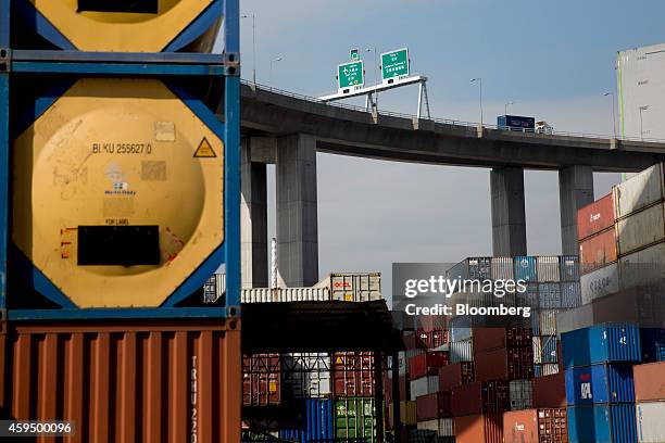 Shipping containers sit stacked near an overpass at the Kwai Tsing Container Terminals in Hong Kong, China, on Monday, Nov. 24, 2014. The Hong Kong...