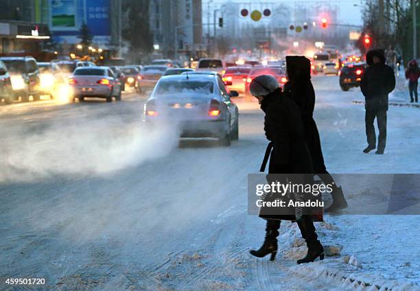 Cars and people are seen on icy Respublika Avenue in Astana where the temperature decreased to -40 centigrade degree, Kazakhstan, on November 24,...