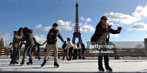 People enjoy at an ice-skating rink set up for the Christmas and New Year celebrations in the Trocadero Square near the Eiffel Tower in Paris, France...