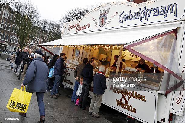 People buy oliebollen from Dutch Donutmaker Richard Visser, the winner of the Dutch contest of the best 'oliebol' , in Rotterdam, The Netherlands, on...