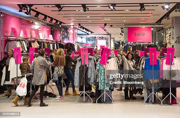 Customers are seen shopping for discounted clothing in a Topshop store, operated by Arcadia Group PLC, at the Westfield Stratford City mall during...