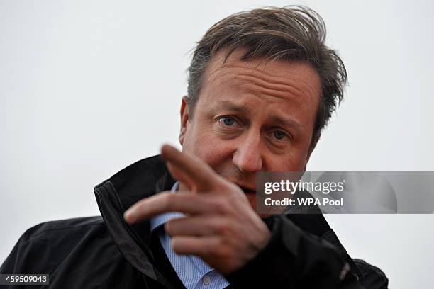 Britain's Prime Minister David Cameron gestures as he speaks to local firefighters in the village of Yalding during a visit on December 27, 2013 in...