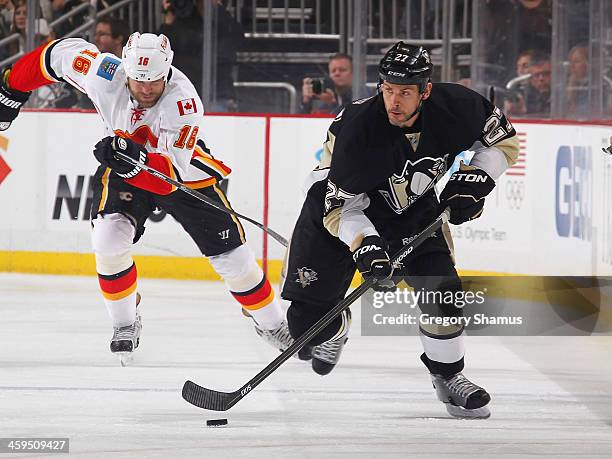 Craig Adams of the Pittsburgh Penguins moves the puck against the Calgary Flames on December 21, 2013 at Consol Energy Center in Pittsburgh,...