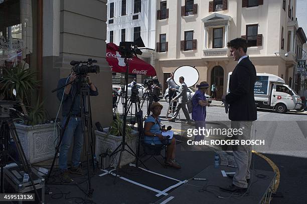 Members of the media broadcast outside the Cape Town High Court, where British murder accused, Shrien Dewani, is standing trial on November 24 in...