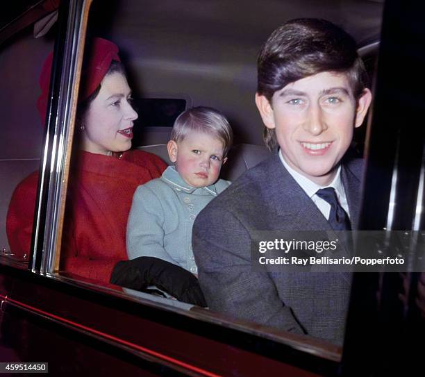 Queen Elizabeth II holding Prince Edward with Prince Charles leaving Liverpool Street Station in London after returning from a Christmas holiday at...