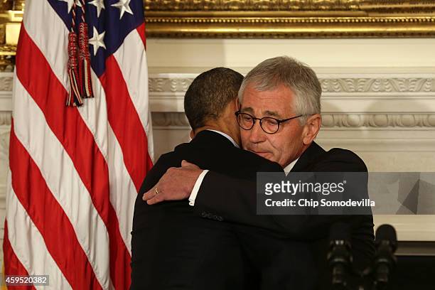 President Barack Obama hugs Secretary of Defense Chuck Hagel during a press conference announcing Hagel's resignation in the State Dining Room of the...