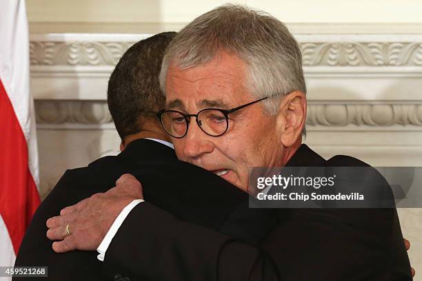 President Barack Obama hugs Secretary of Defense Chuck Hagel during a press conference announcing Hagel's resignation in the State Dining Room of the...