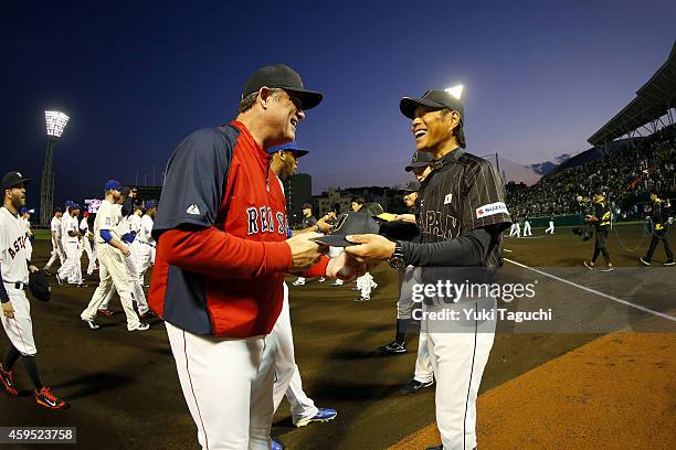 Manger John Farrell of the Boston Red Sox and manager Hiroki Kokubo of Samurai Japan exchange hats before the game at Okinawa Cellular Stadium during...