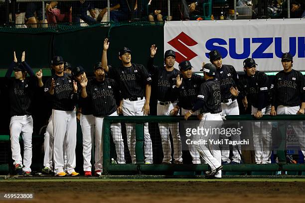 Ginji of Samurai Japan is greeted in the dugout after scoring a run in the eighth inning against the MLB All-Stars during the game at Okinawa...