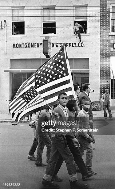 Selma to Montgomery civil rights marchers, with African-American boys holding large and small American flags, Montgomery, Alabama, March 25, 1965....