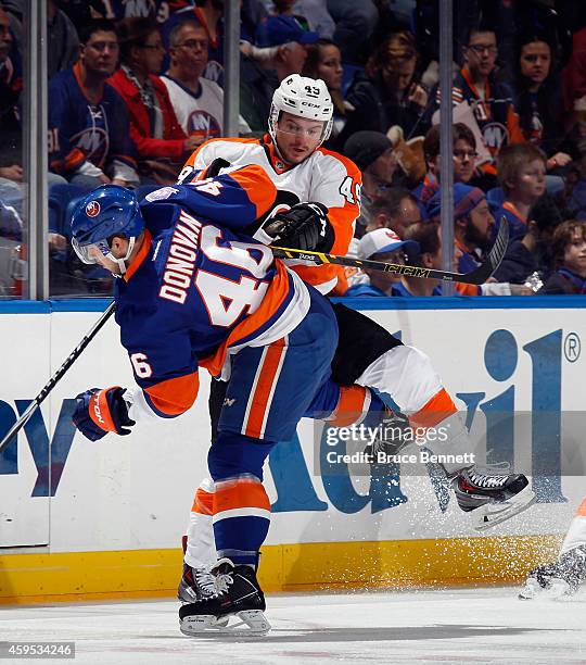 Scott Laughton of the Philadelphia Flyers checks Matt Donovan of the New York Islanders during the first period at the Nassau Veterans Memorial...