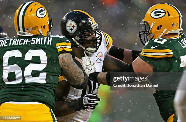 Steve McLendon of the Pittsburgh Steelers rushes against Evan Dietrich-Smith and T.J. Lang of the Green Bay Packers at Lambeau Field on December 22,...