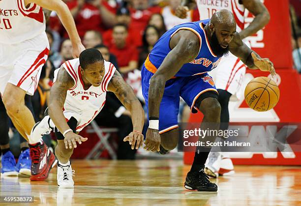Isaiah Canaan of the Houston Rockets and Quincy Acy of the New York Knicks battle for a loose ball during their game at the Toyota Center on November...