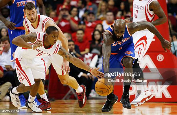 Isaiah Canaan of the Houston Rockets and Quincy Acy of the New York Knicks battle for a loose ball during their game at the Toyota Center on November...