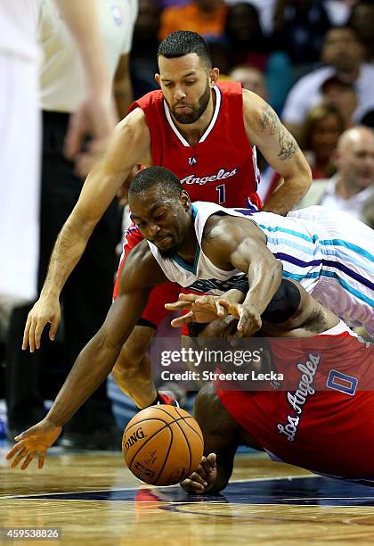 Jordan Farmar watches as his teamamte Glen Davis of the Los Angeles Clippers goes after a loose ball against Kemba Walker of the Charlotte Hornets...