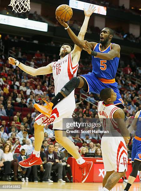 Tim Hardaway Jr. #5 of the New York Knicks takes a shot over Kostas Papanikolaou and Isaiah Canaan of the Houston Rockets at the Toyota Center on...