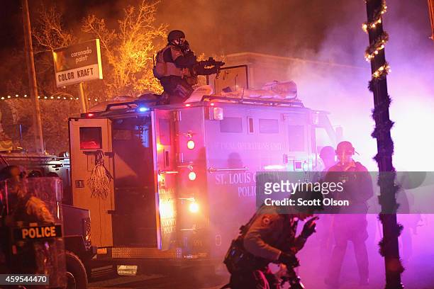 Police confront protestors after rioting broke out following the grand jury announcement in the Michael Brown case on November 24, 2014 in Ferguson,...