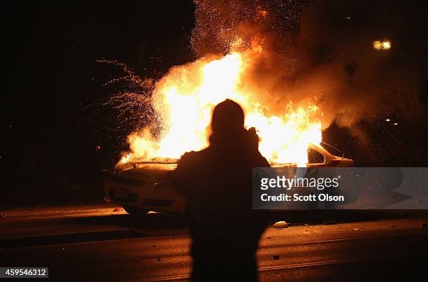 Squad car burns after protestors rioted following the grand jury announcement in the Michael Brown case on November 24, 2014 in Ferguson, Missouri....