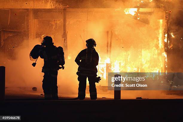 Firefighters try to extinguish a burning restaurant set on fire after protestors rioted following the grand jury announcement in the Michael Brown...