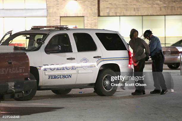 Suspected looter is aprehended outside a Dollar Store when protestors rioted following the grand jury announcement in the Michael Brown case on...