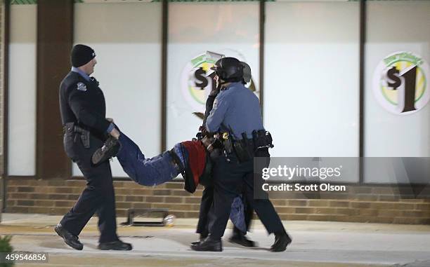 Suspected looter is aprehended outside a Dollar Store when protestors rioted following the grand jury announcement in the Michael Brown case on...