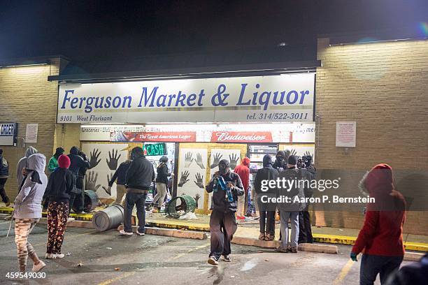 Looters run out of a business during rioting on November 24, 2014 in Ferguson, Missouri. A St. Louis County grand jury has declined to indict...