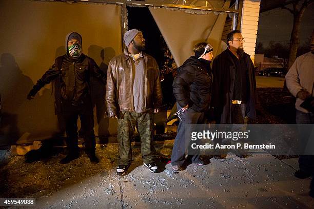 Protestors protect a looted business during rioting on November 24, 2014 in Ferguson, Missouri. A St. Louis County grand jury has declined to indict...