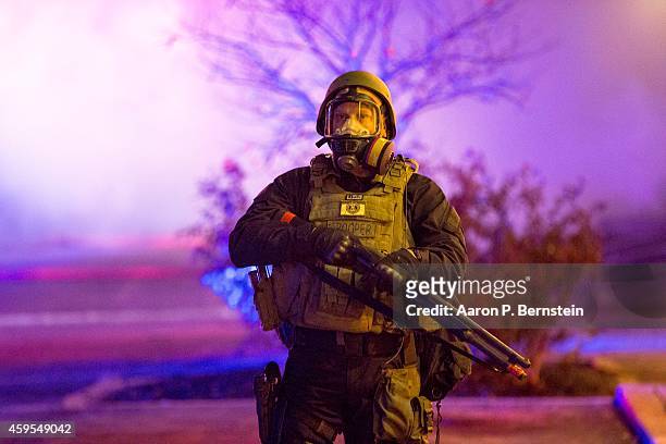 Police stand guard during rioting on November 24, 2014 in Ferguson, Missouri. A St. Louis County grand jury has declined to indict Ferguson police...