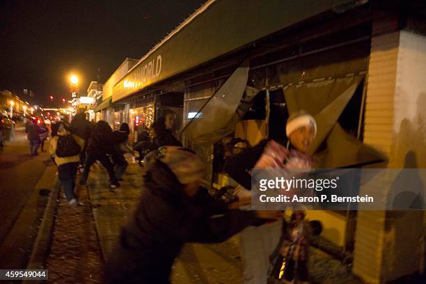 Looters run out of a business during rioting on November 24, 2014 in Ferguson, Missouri. A St. Louis County grand jury has declined to indict...