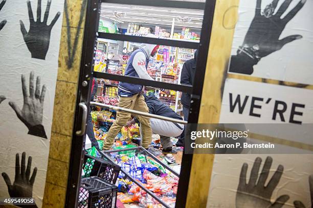 Looters run out of a business during rioting on November 24, 2014 in Ferguson, Missouri. A St. Louis County grand jury has declined to indict...