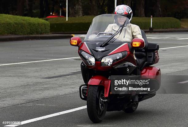 Takanobu Ito, president and chief executive officer of Honda Motor Co., rides a Gold Wing motorcycle during an event at the company's Kumamoto...