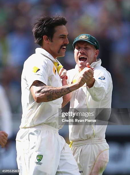 Mitchell Johnson of Australia celebrates with David Warner of Australia after taking the wicket of Jonny Bairstow of England during day three of the...