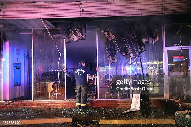 Ferguson firefighter surveys damage at a strip mall that was set on fire when rioting erupted following the grand jury announcement in the Michael...
