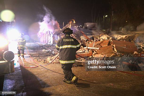 Ferguson firefighters pack up after extinguishing a fire at a strip mall that was set on fire when rioting erupted following the grand jury...