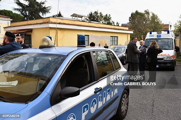 People stand next to police cars at the main entrance of the Lazzaro Spallanzani Institute in Rome on November 25, 2014. A doctor, 50-years old from...