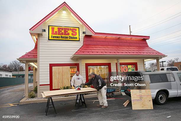 Workers board up a window of a restaurant after it was smashed when rioting erupted following the grand jury announcement in the Michael Brown case...