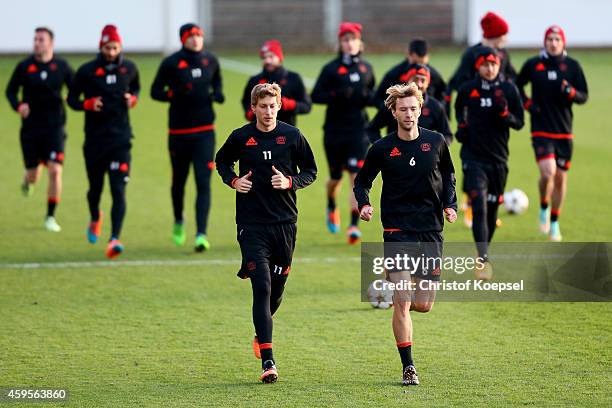 The team of Leverkusen and Stefan Kiessling and Simon Rolfes warm up during a Bayer Leverkusen training session ahead of their UEFA Champions League...