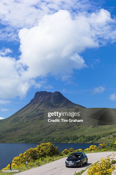 Motorist on touring holiday by Stac Pollaidh, Stack Polly glacier mountain in Inverpolly National Nature Reserve in Coigach area of North West...