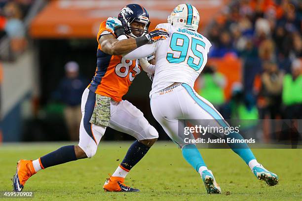 Tight end Virgil Green of the Denver Broncos blocks defensive end Dion Jordan of the Miami Dolphins during a game at Sports Authority Field at Mile...