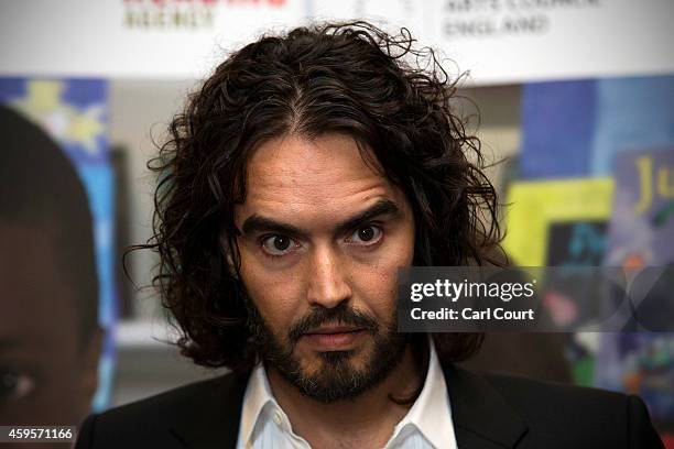 Russell Brand poses for photographs as he arrives to deliver The Reading Agency Lecture at The Institute of Education on November 25, 2014 in London,...