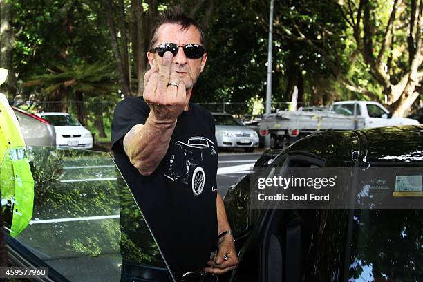Drummer Phil Rudd gestures to members of the media after leaving Tauranga District Court after appearing in court after being charged with...