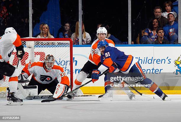 John Tavares of the New York Islanders takes the shot against Steve Mason of the Philadelphia Flyers at the Nassau Veterans Memorial Coliseum on...