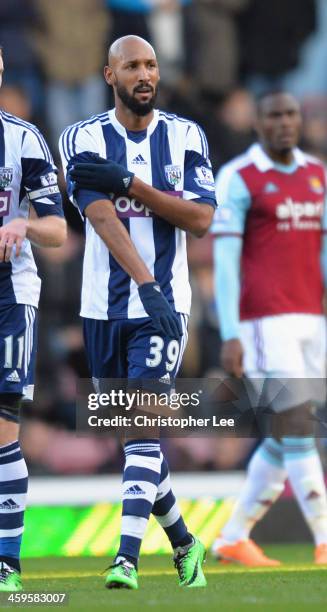 Nicolas Anelka of West Brom touches his sleeve as he celebrates scoring their first goal during the Barclays Premier League match between West Ham...