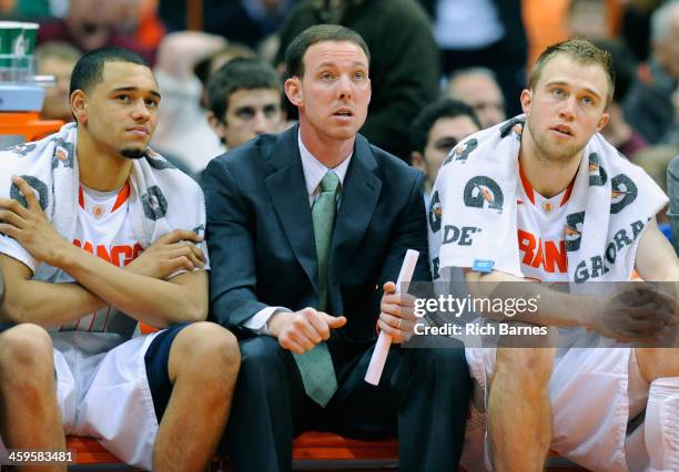 Tyler Ennis, assistant coach coach Gerry McNamara and Trevor Cooney of the Syracuse Orange looks on against the High Point Panthers during the second...