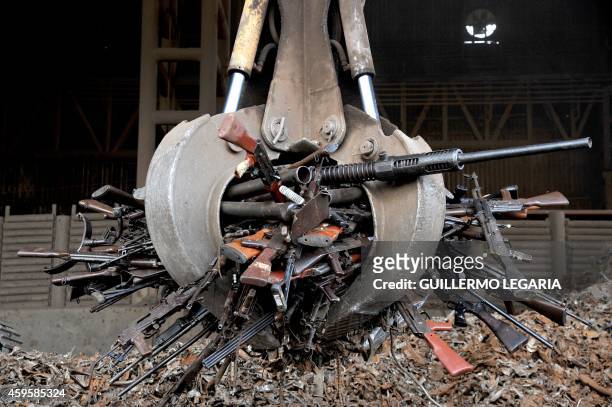 Crane carry part of 9,517 weapons seized from the FARC and ELN guerrillas criminal gangs and organized crime, before being melted in furnaces of the...