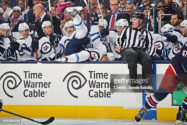 Evander Kane of the Winnipeg Jets falls into his bench after being checked during the second period of a game against the Columbus Blue Jackets on...