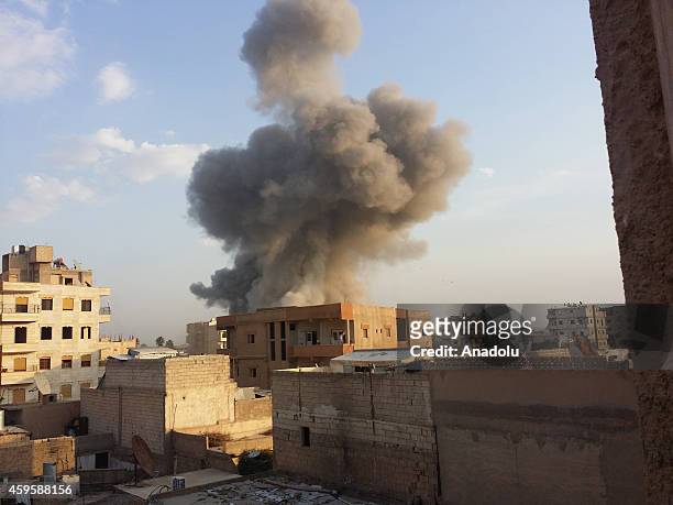 Smoke rises after air strikes by Syrian army warplanes on the ISIL-held northern city of Raqqa, Syria on November 25, 2014. At least 130 people have...