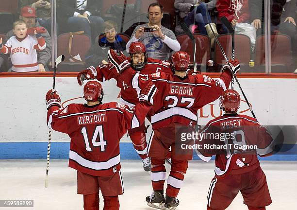 Kyle Criscuolo of the Harvard Crimson celebrates his overtime winning goal against the Boston University Terriers with his teammates Alexander...