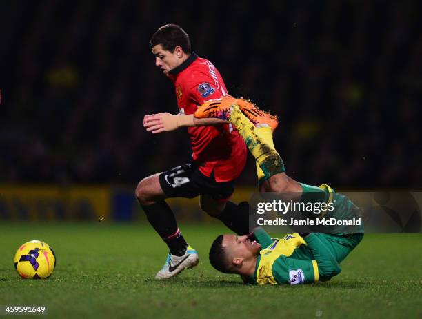 Martin Olsson of Norwich City tangles with Javier Hernandez of Manchester United during the Barclays Premier League match between Norwich City and...