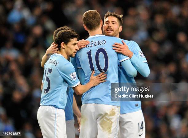 Edin Dzeko of Manchester City is congratulated by team-mates Javi Garcia and Jesus Navas during the Barclays Premier League match between Manchester...